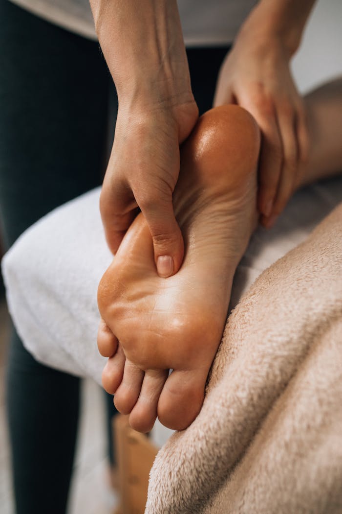 services-01 Hands massaging a foot to provide relaxation and promote wellness indoors.